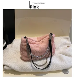 Détail du sac à main rose en fausse fourrure avec motifs cœurs et chaînes argentées