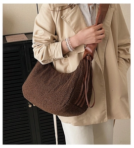 Detail of dark brown teddy hobo bag with smooth leather strap and fringe accents