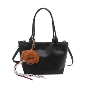Black leather tote bag with teddy bear charm, crossbody strap and embossed letters