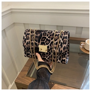 Close-up of leopard print shoulder bag featuring a gold chain strap and metal clasp