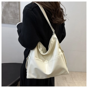Detail view of large cream PU leather tote bag showing side stitching and soft texture
