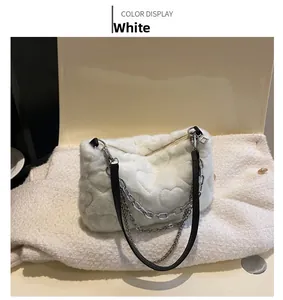 Détail du sac à bandoulière en fausse fourrure blanche avec motif de cœur et chaînes