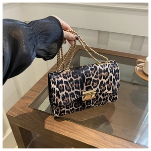 Close-up of leopard print small square bag with golden chain strap and twist lock detail