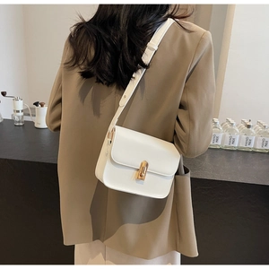 White minimalist leather square crossbody bag worn over a stylish brown autumn coat