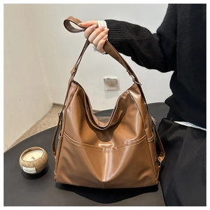 Close-up of vintage brown PU leather tote bag with decorative pocket and stitching detail