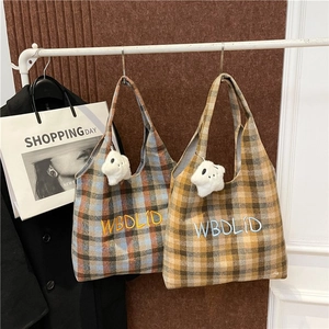 Close-up of retro plaid tote bags with letter embroidery and white furry star charms
