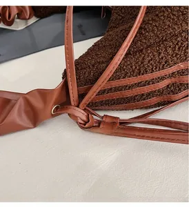 Detail view of the adjustable knotted leather strap on brown teddy plush crossbody bag