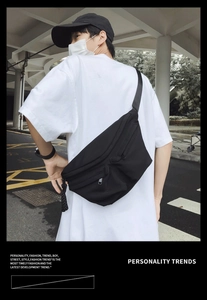 Detailed back view of a large black waterproof nylon crossbody chest bag on a model