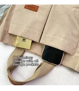 Detail of corduroy tote bag featuring front pockets for phone and makeup storage