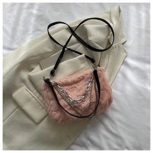 Détail du sac à main en peluche rose avec texture gaufrée en cœur et chaînes argentées