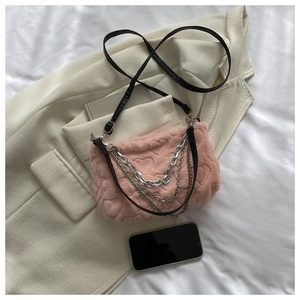 Détail du sac en peluche rose avec matelassage cœur et chaînes argentées superposées