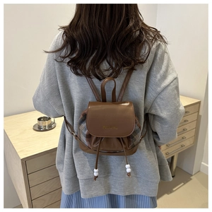 Detail of vintage brown leather and plaid fabric mini backpack with Fashion lettering