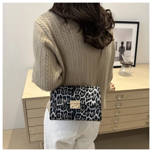 Detailed view of leopard print shoulder bag with gold chain strap and metal lock