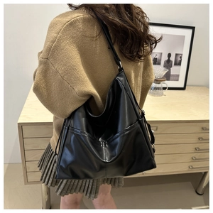Side view of large black faux leather hobo bag with adjustable strap and side pocket