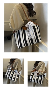 Detail of striped canvas tote bag with white lace floral bow and brown leather straps