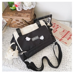 Detail of canvas messenger bag featuring contrast colors and cute teddy bear plush charm