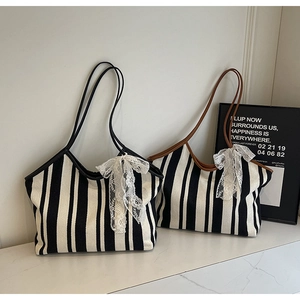 Detail of striped canvas tote bags with leather handles and decorative lace bows