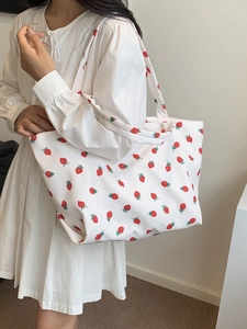 Close-up of a white nylon tote bag featuring a vibrant red strawberry print and large capacity