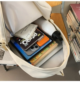 Interior view of spacious cream canvas backpack organized with laptop and daily essentials