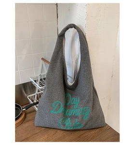 Detailed shot of dark grey felt tote bag featuring green Day Dreaming Club embroidery