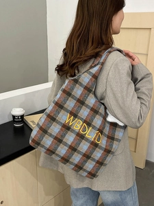 Detail of vintage plaid tote bag with yellow embroidered letters and soft furry lining