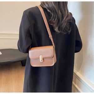 Detailed back view of a brown matte leather square crossbody bag with gold U-shaped buckle