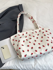 Flat lay of white nylon strawberry print tote bag with tablet and business casual accessories