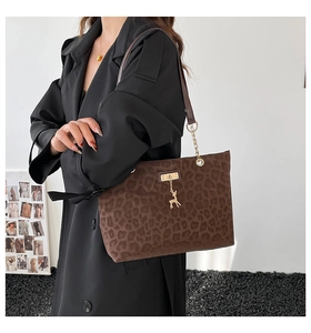 Detail of leopard print tote bag with golden deer pendant and premium leather handle