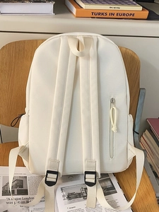 Minimalist cream canvas backpack for couples with side zipper on a wooden chair