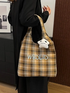 Detail of vintage plaid tote bag with letter embroidery and white star plush charm