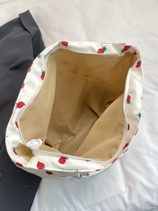 Detailed top view of nylon strawberry tote bag showing white zipper and interior lining
