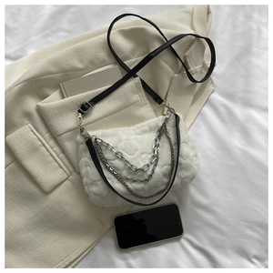 Détail du sac bandoulière en peluche blanche avec matelassage cœur et chaînes