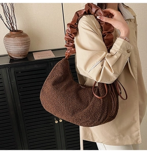 Detail of plush brown shoulder bag with soft faux shearling texture and ruched leather strap
