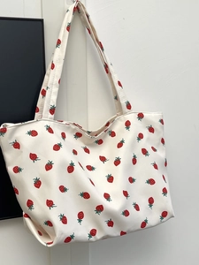 Detailed view of durable strawberry print nylon fabric on a spacious shoulder tote bag