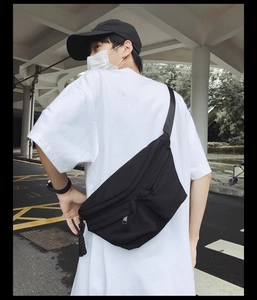 Close-up of black tactical nylon crossbody bag with adjustable strap on a male model