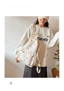 Détail d'un sac à dos en toile beige avec motifs de teckels bruns pour l'école et les loisirs