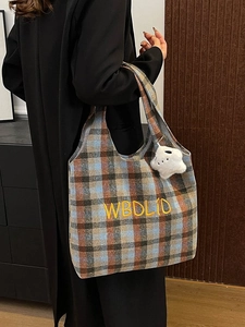 Detail of vintage plaid wool tote bag with letter embroidery and bear charm accessory
