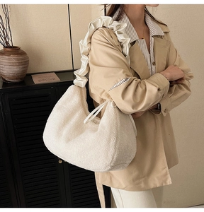 Detail of white faux fur shoulder bag featuring elegant ruffled satin shoulder strap detail