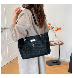 Close-up of black leopard print tote bag with velvet texture and deer charm detail