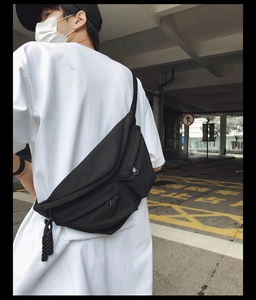 Close-up of a black utilitarian crossbody bag with durable nylon and multi-pocket design