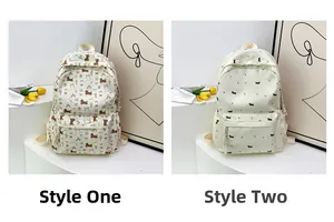 Détail de sacs à dos en toile à fleurs avec motifs chiots et nœuds en blanc crème