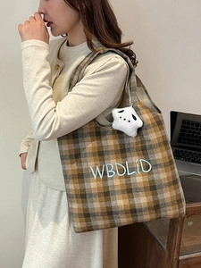 Detail of retro plaid tote bag with blue embroidery and white star plush charm