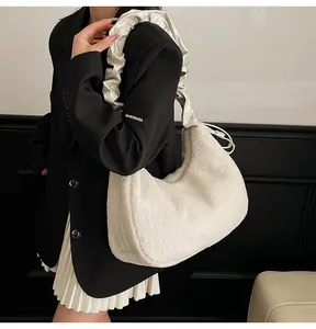 Detail of white plush faux fur hobo bag with a satin pleated strap on a model shoulder