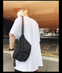 Outdoor shot showing details of black sports crossbody bag with durable woven pull zippers