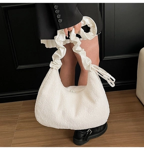 Detail of soft cream faux fur shoulder bag with stylish ruched handle and half-moon shape