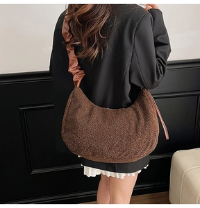 Detail of a brown teddy fur hobo bag featuring a pleated strap and white ruffled trim