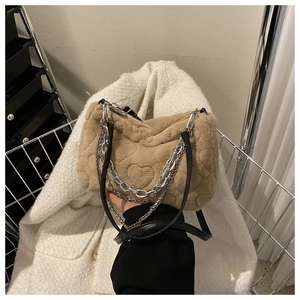 Détail du sac à main en peluche kaki avec motifs de cœurs embossés et chaîne argentée