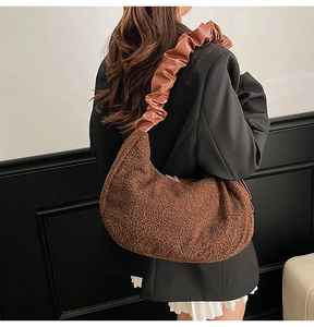 Detail of plush hobo bag featuring dark brown faux fur and a wrinkled leather strap