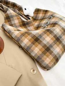 Detailed close-up of vintage plaid wool tote bag with embroidery and plush bunny pendant