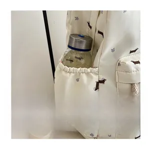 Détail de la poche latérale élastique du sac à dos beige à motif floral et gourde